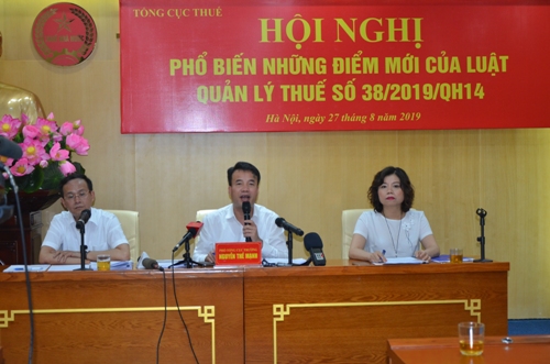 Ông Nguyễn Thế Mạnh (giữa) trả lời câu hỏi của các phóng viên về Luật Quản lý thuế số 38.