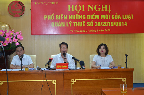 Ông Nguyễn Thế Mạnh (giữa) trả lời câu hỏi của các phóng viên về Luật Quản lý thuế số 38. 